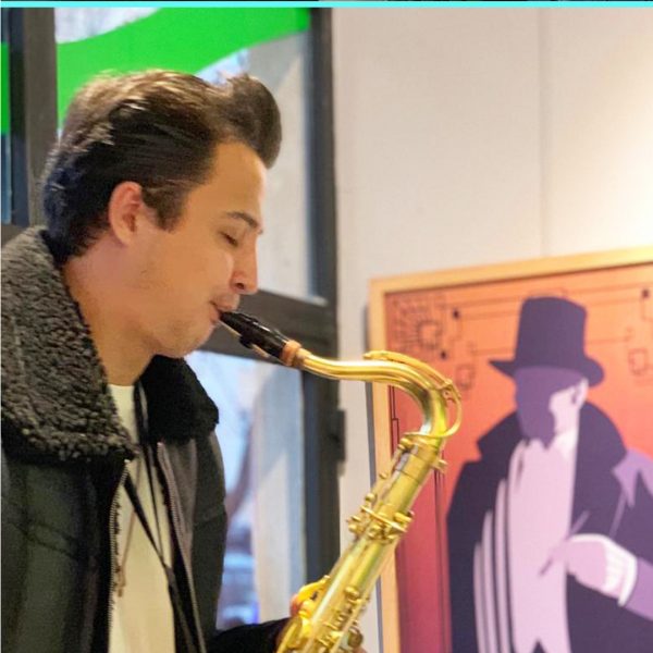Fil Sanat Alan Jazz Dinletisi Arkada Atatürk resmi ve önde saksafon çalan jazz sanatçısı